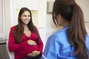 Smiling brunette nurse talking with a male patient